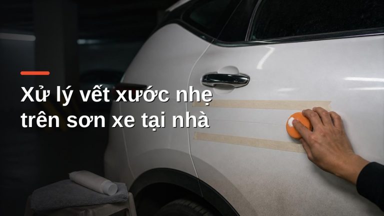Dùng pad xốp và kem đánh bóng xử lý vết xước nhẹ trên cửa xe sơn trắng, khu vực được khoanh bằng băng keo giấy